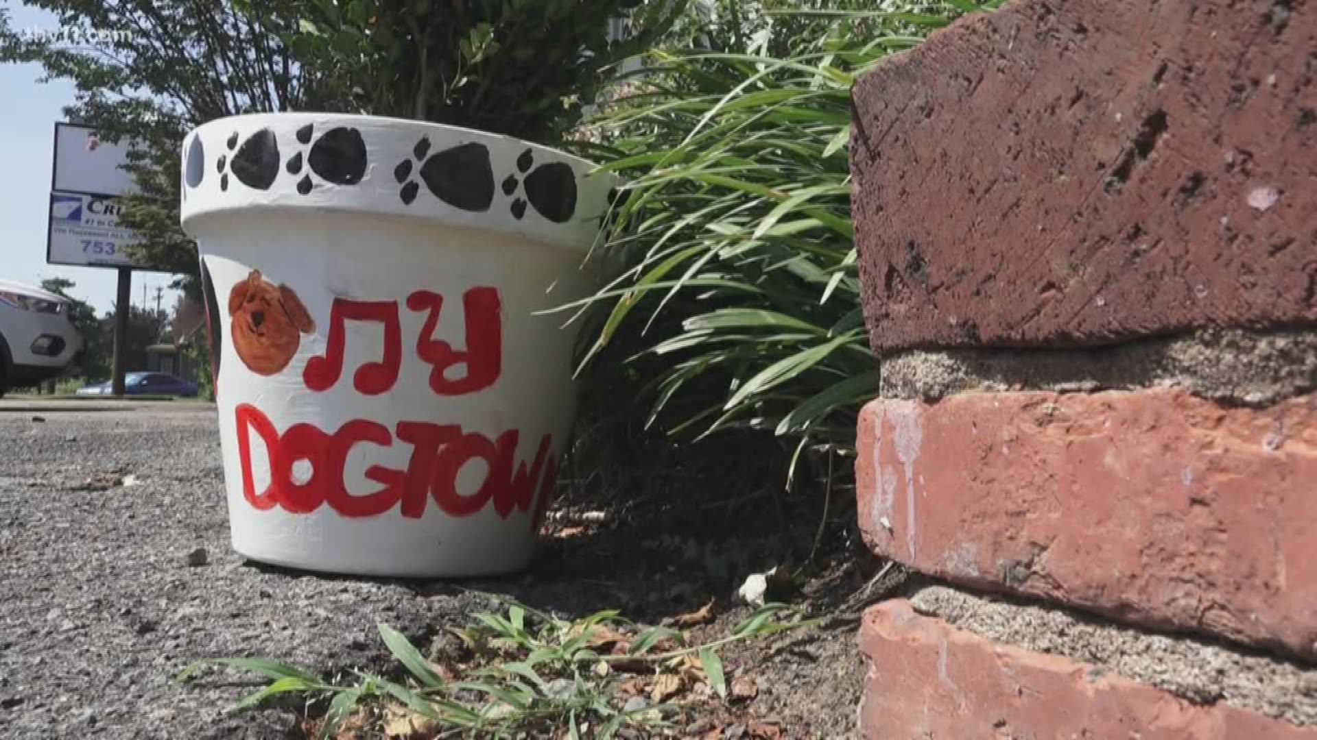 Flower pots outside North Little Rock businesses beautify the area with local art.
