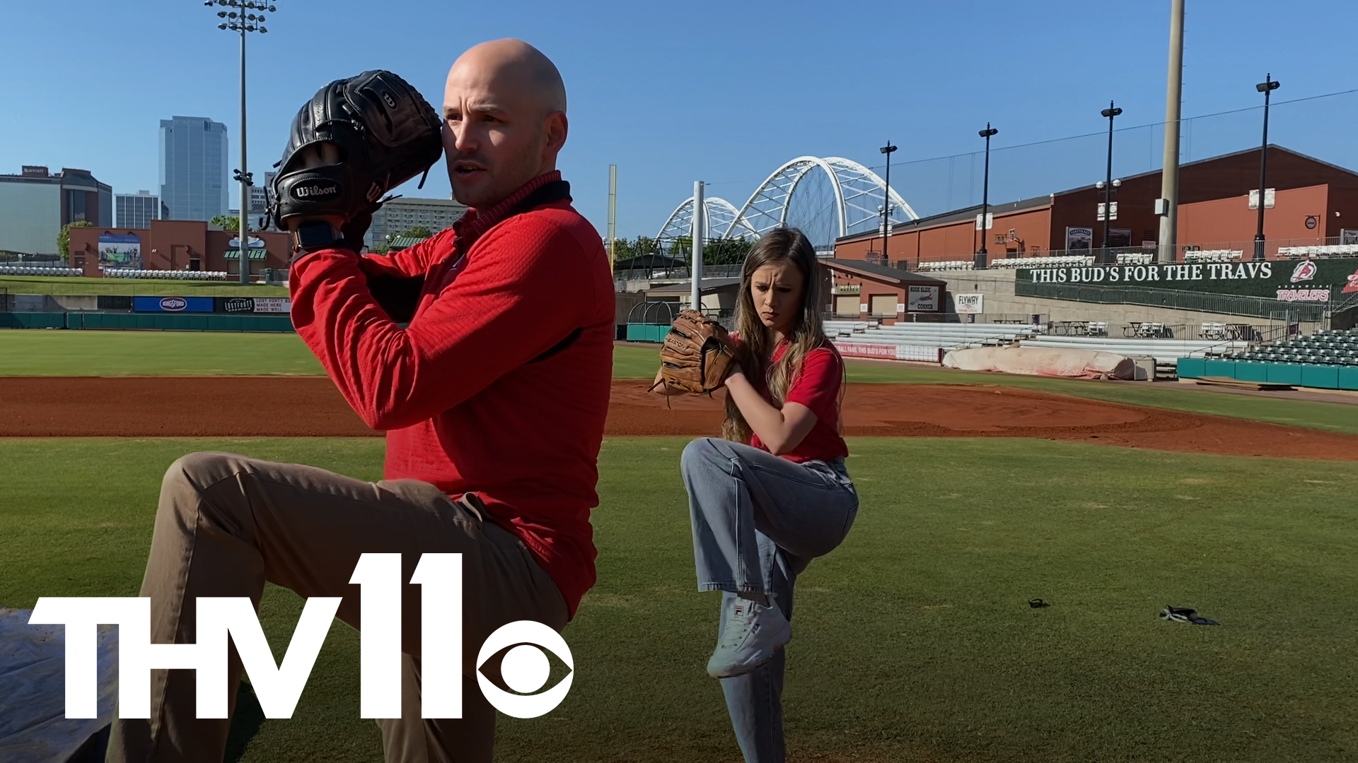 Hana Williams gets a few pitching tips from Arkansas Travelers' Executive Vice President and CEO Rusty Meeks.