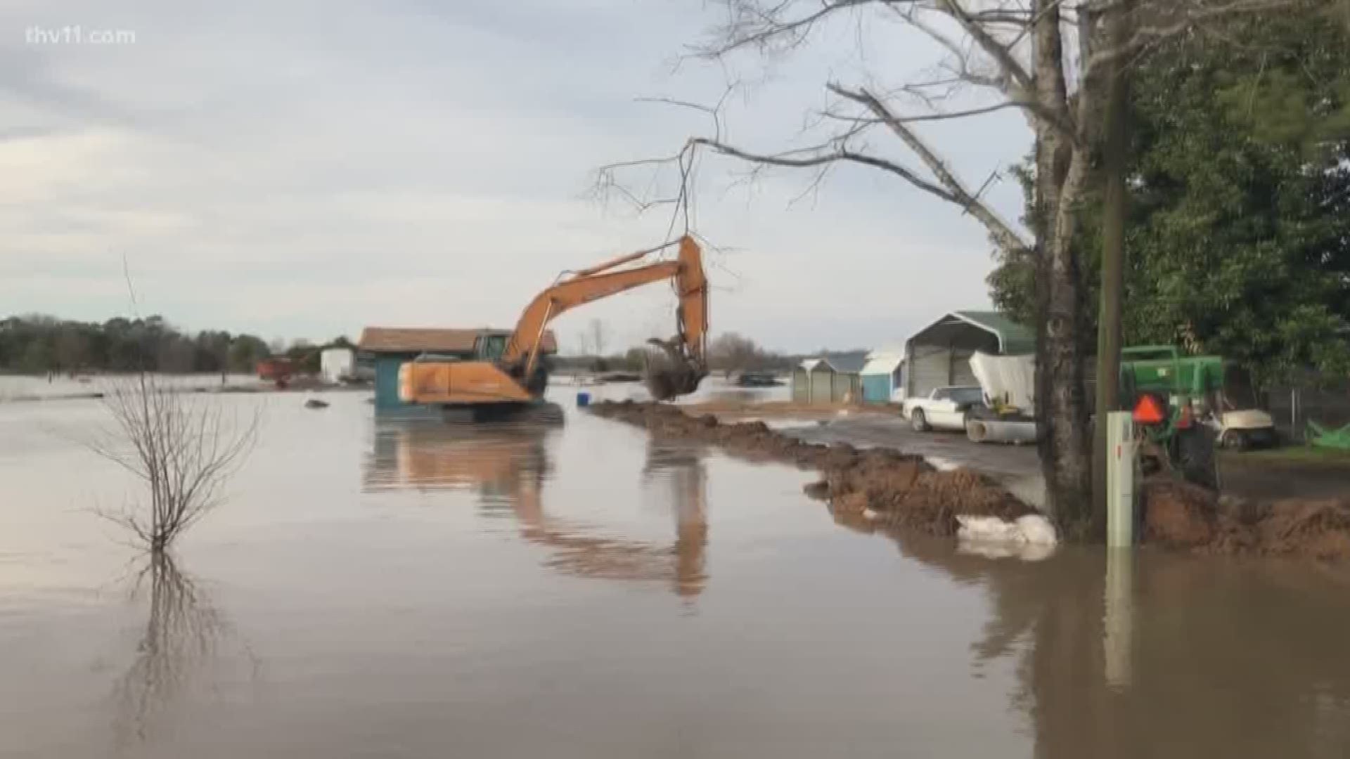 A northeast Arkansas community is using heavy machinery to stave off flooding from homes and the area's church.