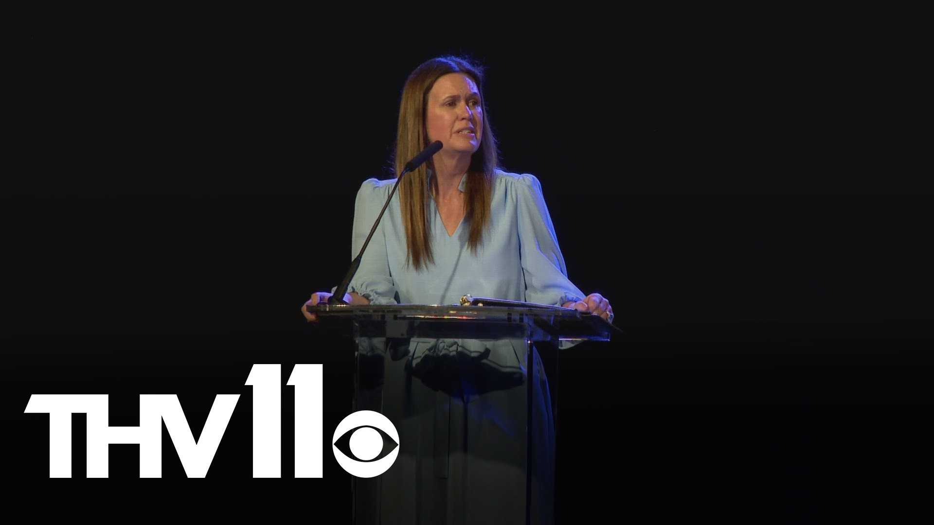 Governor Sarah Sanders celebrates Arkansas's economic success by showing studies and reports.